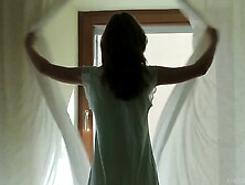Long Haired Brunette Pulls Open Her Drapes Before Gazing Out Window,  Lies Back On Bed