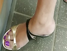 Voyeur films sexy lady at the bank wearing golden high heel shoes on her pretty feet