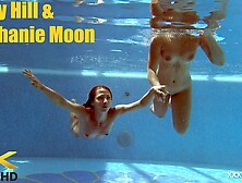 In the indoor pool,  two stunning girls swim