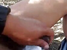 A guy playing with his friends cock outdoor