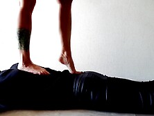 Trampling. Dominatrix Nika walks on the back of her slave with bare feet