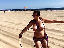 Hot beach girl shows off her hula hoop skills