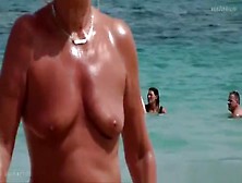 The Old Woman Is Walking Topless On The Beach