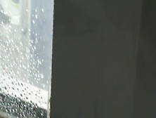 Topless girl in jeans with wet head on window video