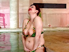 Redhead Lisa Pinelli enjoys solo sex in the pool wearing a bikini