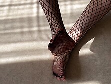 Girl In Black Fishnet Pantyhose Caresses Her Legs