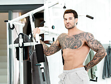 Handsome Man With Tattoos Working Out With A Hunk