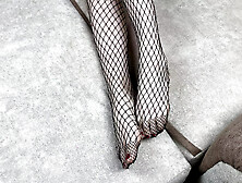 Mistress In Black Fishnet Stockings Caresses Her Legs With Pedicure