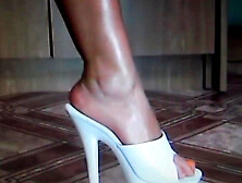 MILF showing off her tanned legs and sexy feet with orange toe nails in her high heels