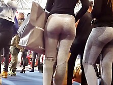 Two candid fit asses in grey yoga pants walking