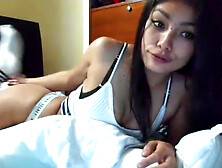 Asian babe shows her feet while inserting her fingers into her mouth on the cam