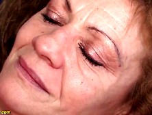 Older golden-haired woman in erotic,  red nylons and matching underware is having sex with a younger stud