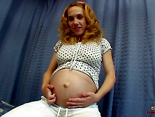 Pregnant blonde babe uses a big glass dildo on her shaved pussy while lying on the bed